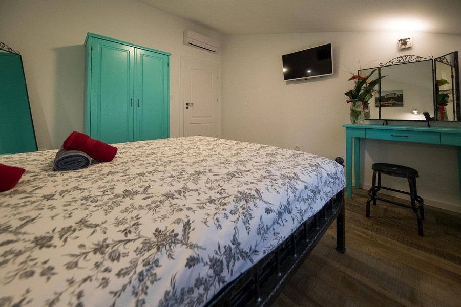 Ložnice s manželskou postelí a nástěnným zrcadlem