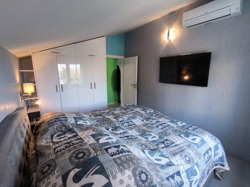 Ložnice s velkou postelí a televizí