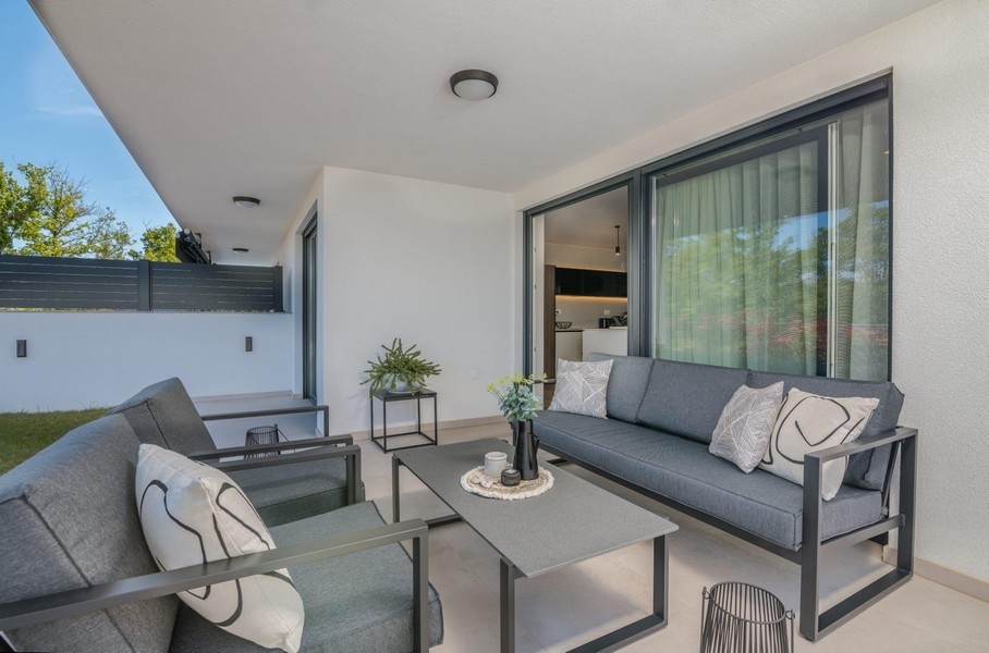 Krytá terasa s moderním posezením a výhledem do zahrady