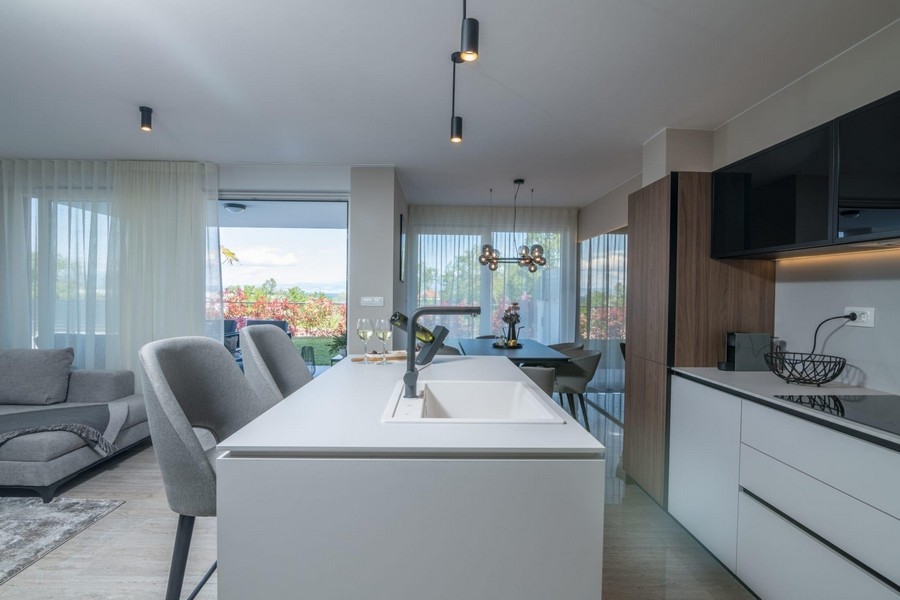 Otevřený obývací prostor s moderní kuchyní a jídelním koutem