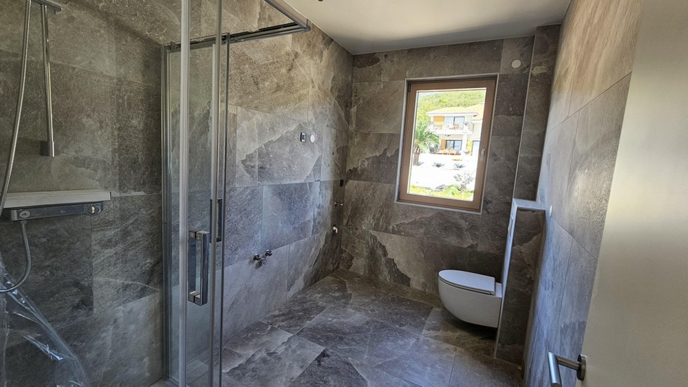 Moderní koupelna se sprchovým koutem a oknem