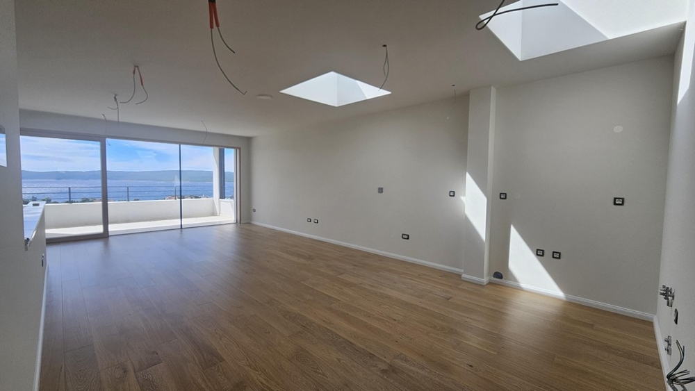 Světlý obývací pokoj s výhledem na moře a parketami