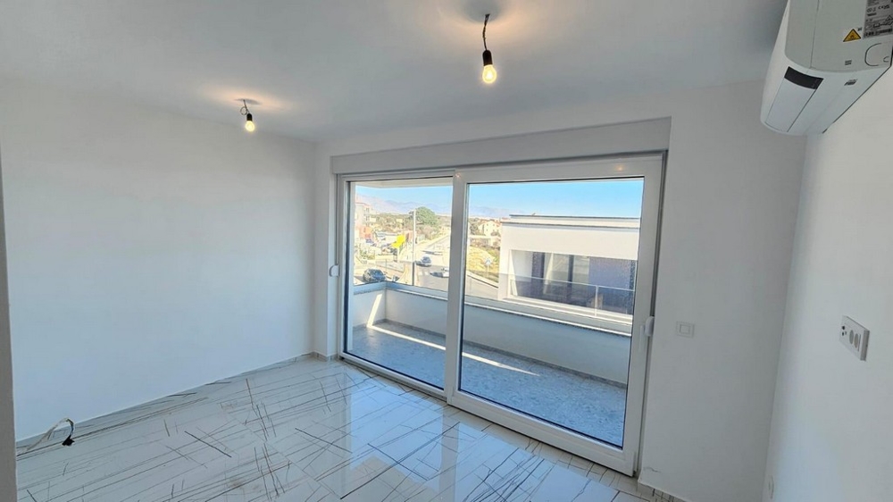 Druhá ložnice se vstupem na balkon a výhledem na obytný komplex