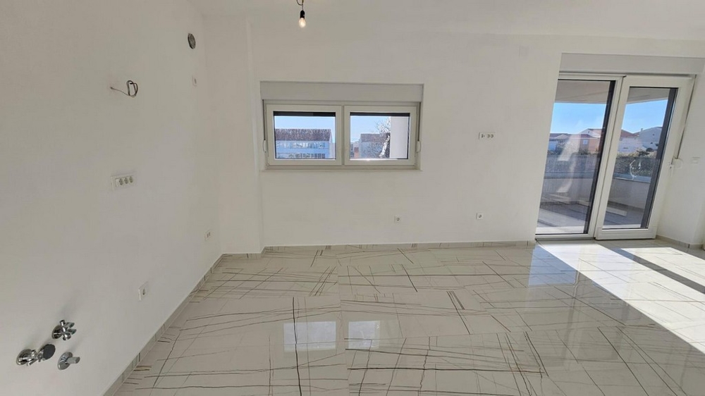 Obytná část s dlažbou a vstupem na terasu