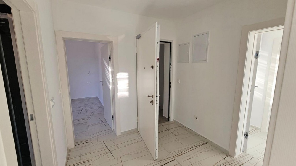 Předsíň s bílými vstupními dveřmi a přístupem do dalších místností