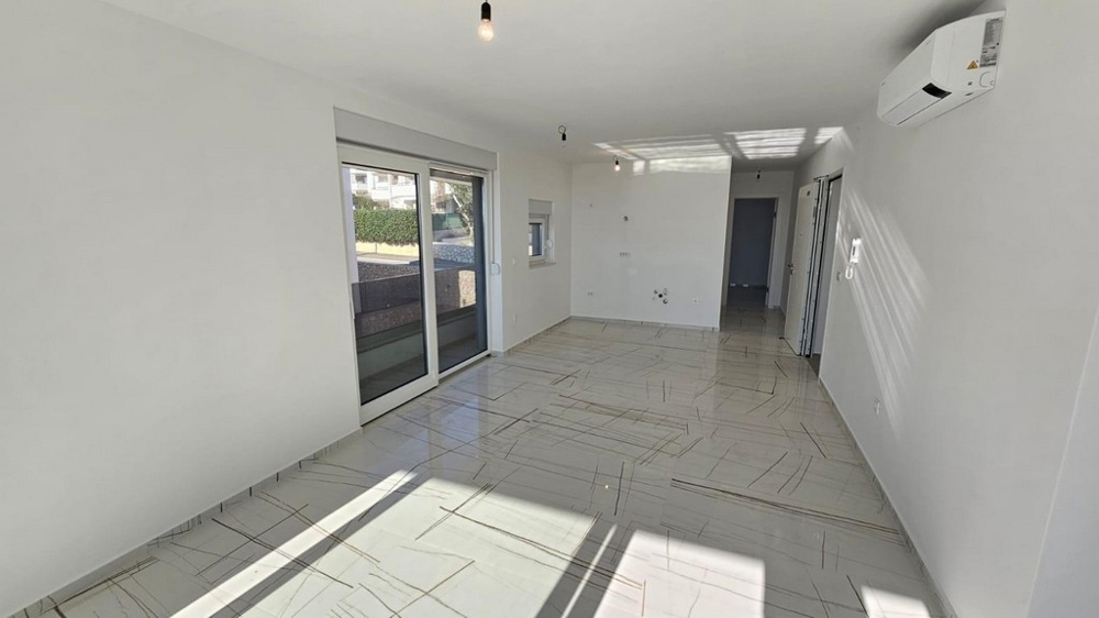 Obývací prostor se spoustou přirozeného světla a vstupem na terasu