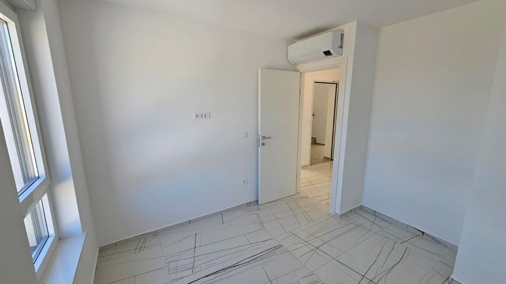 Světlá dlažba v klimatizované ložnici.