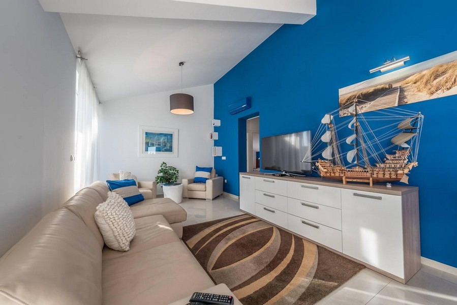 Útulný obývací pokoj s velkou pohovkou a TV