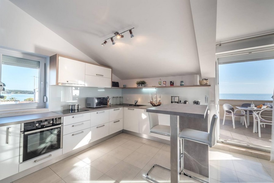 Moderní kuchyně s výhledem na moře a přístupem na terasu