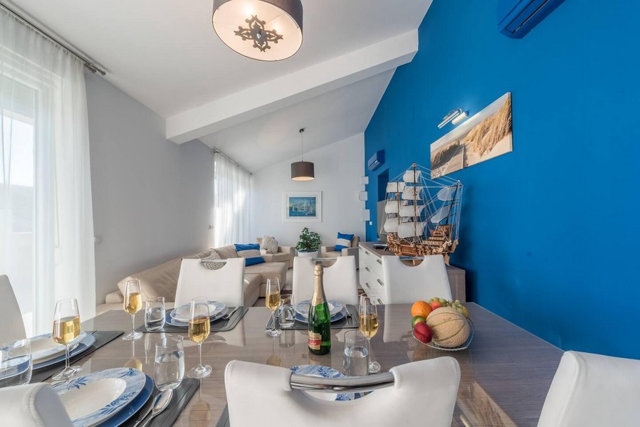 Jídelní kout s prostřeným stolem a výhledem do obývacího pokoje