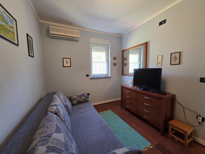 Ložnice s pohovkou, komodou a televizí