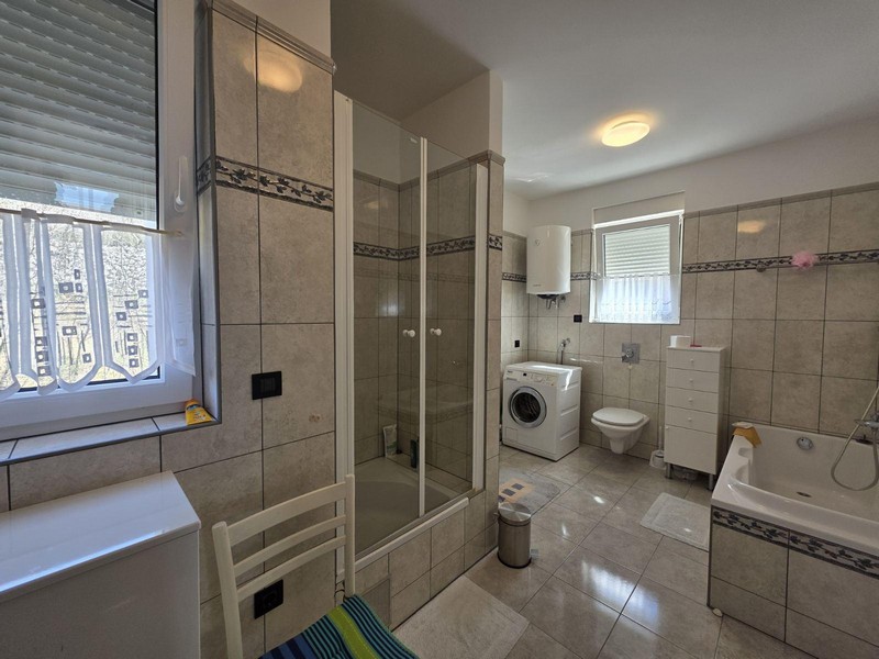 Velká koupelna se sprchovým koutem, vanou a pračkou