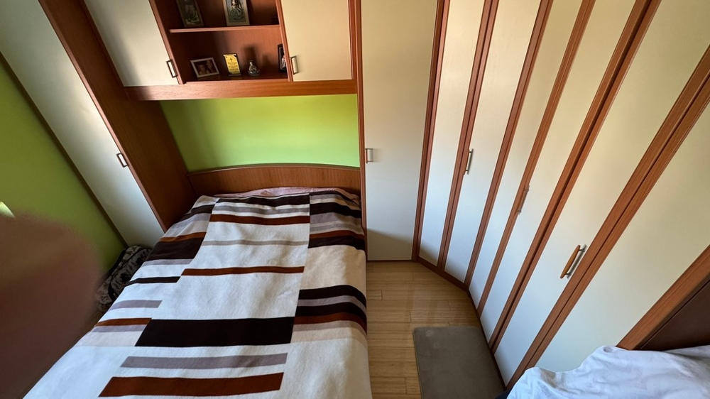 Ložnice se skříní a úložnými prostory nad postelí