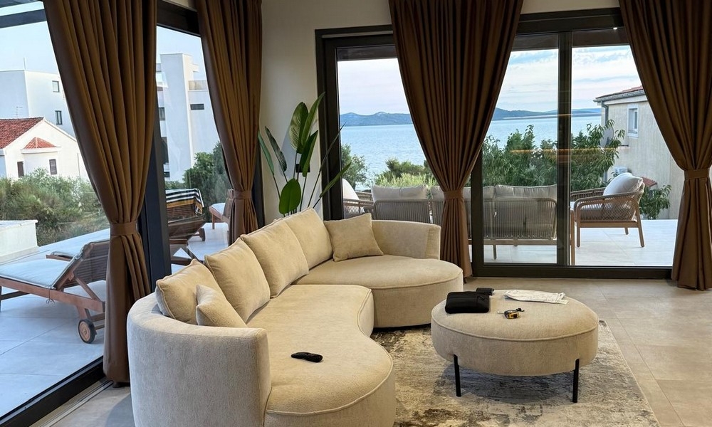 Obývací pokoj s velkým předním oknem a výhledem na moře