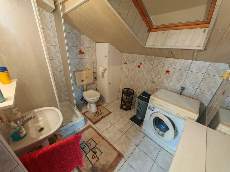 Koupelna se sprchovým koutem, pračkou a střešním oknem