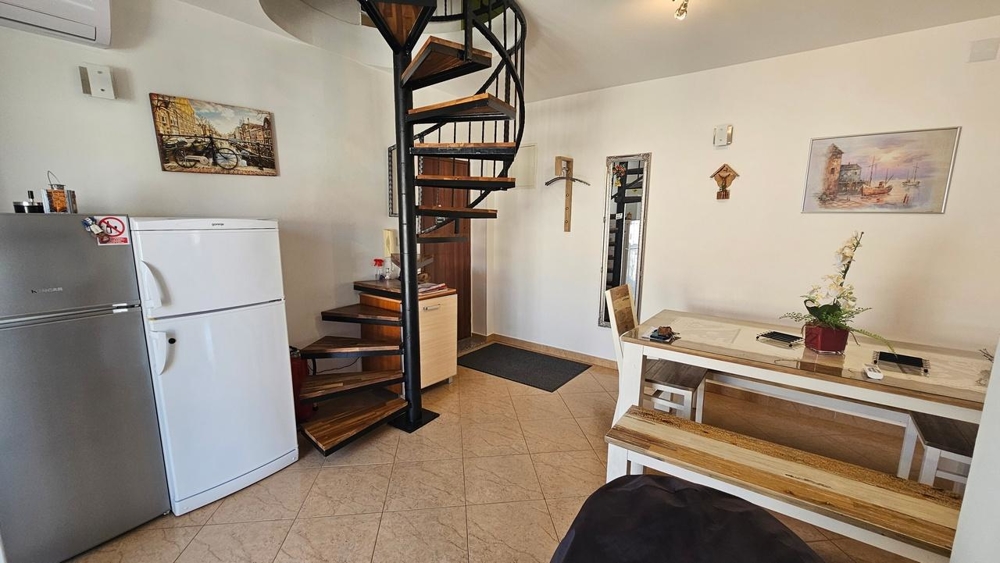 Obývací část s točitým schodištěm a lednicí