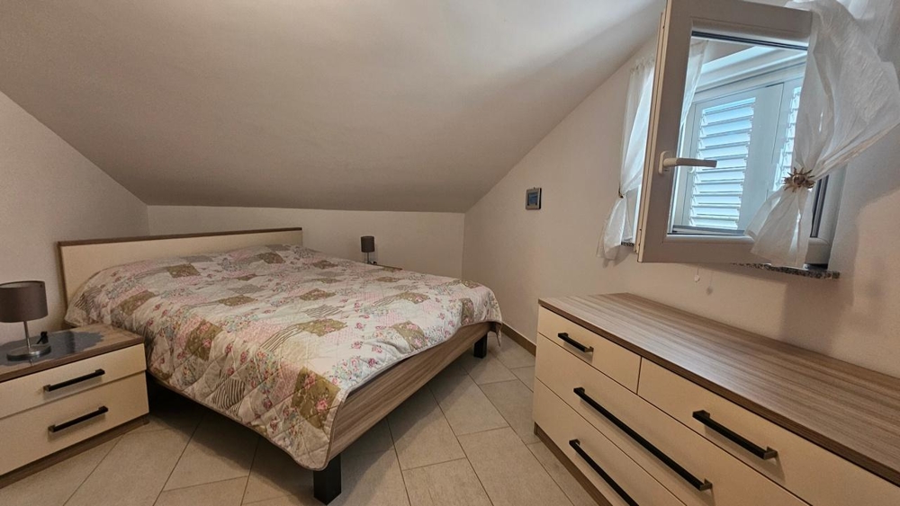 Ložnice s manželskou postelí a komodou