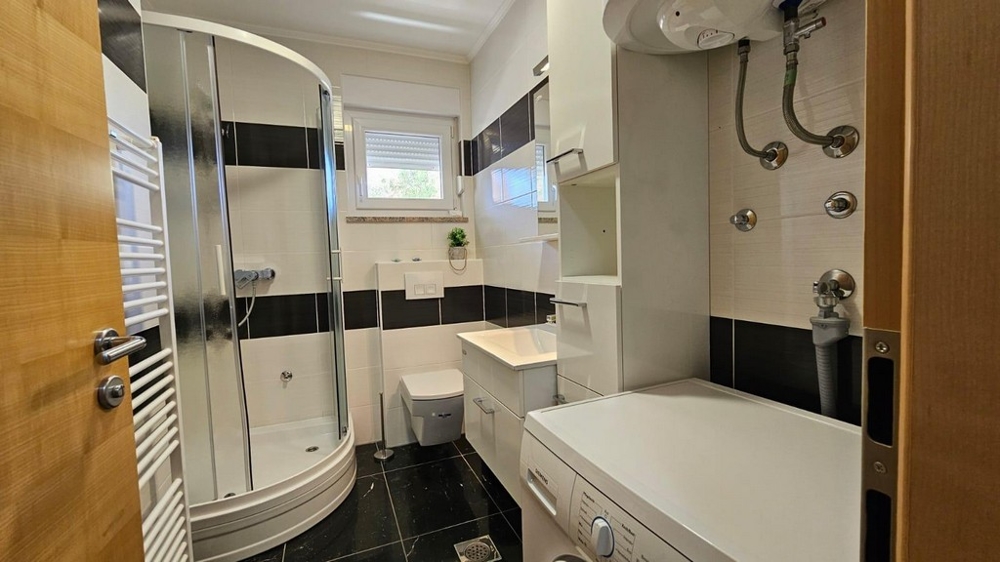 Koupelna se sprchovým koutem a pračkou