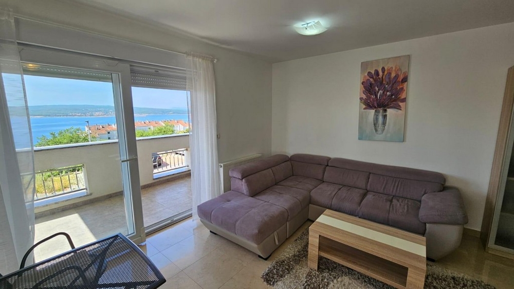 Zařízený obývací pokoj s výhledem na moře.