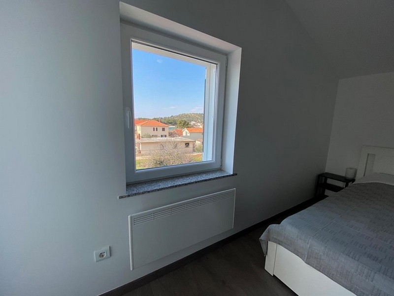 Výhled z okna na sousední domy a přírodu