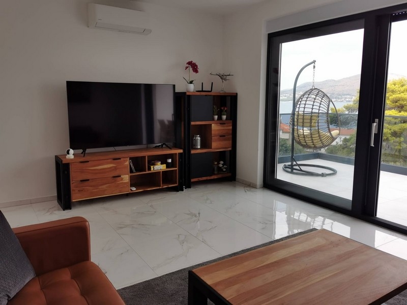 Obývací pokoj s TV a výhledem na moře