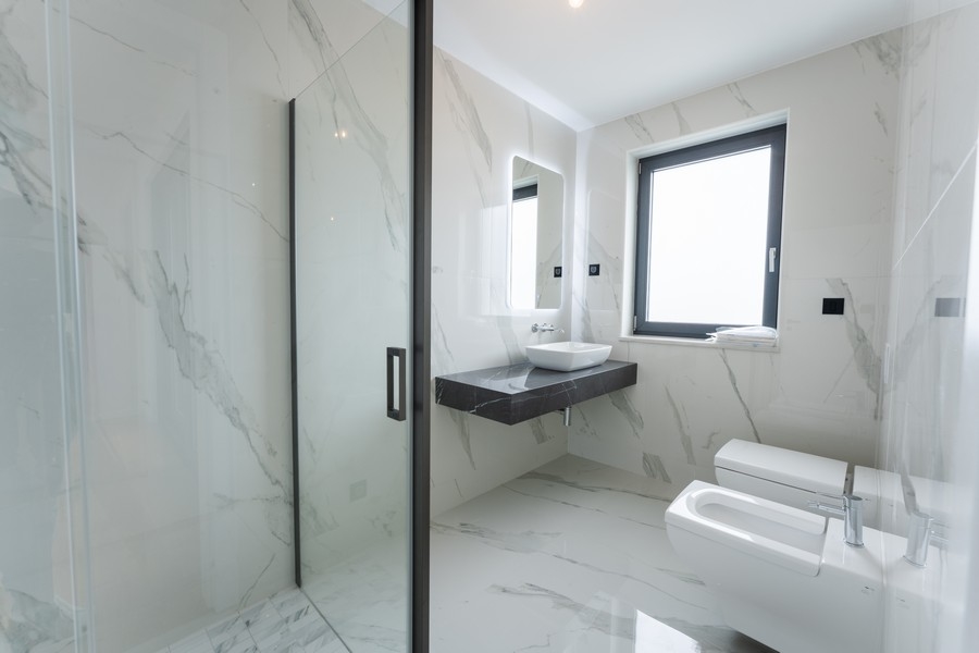 Koupelna se sprchovým koutem a mramorovými obklady