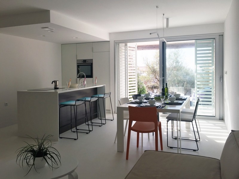 Světlá kuchyně s barem a jídelním koutem u okna