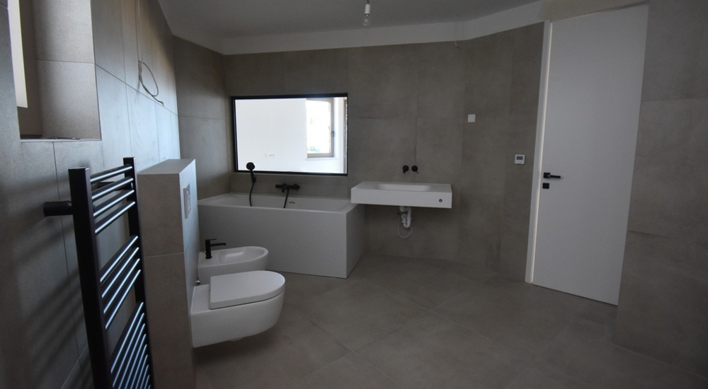 Prostorná koupelna s vanou a toaletou