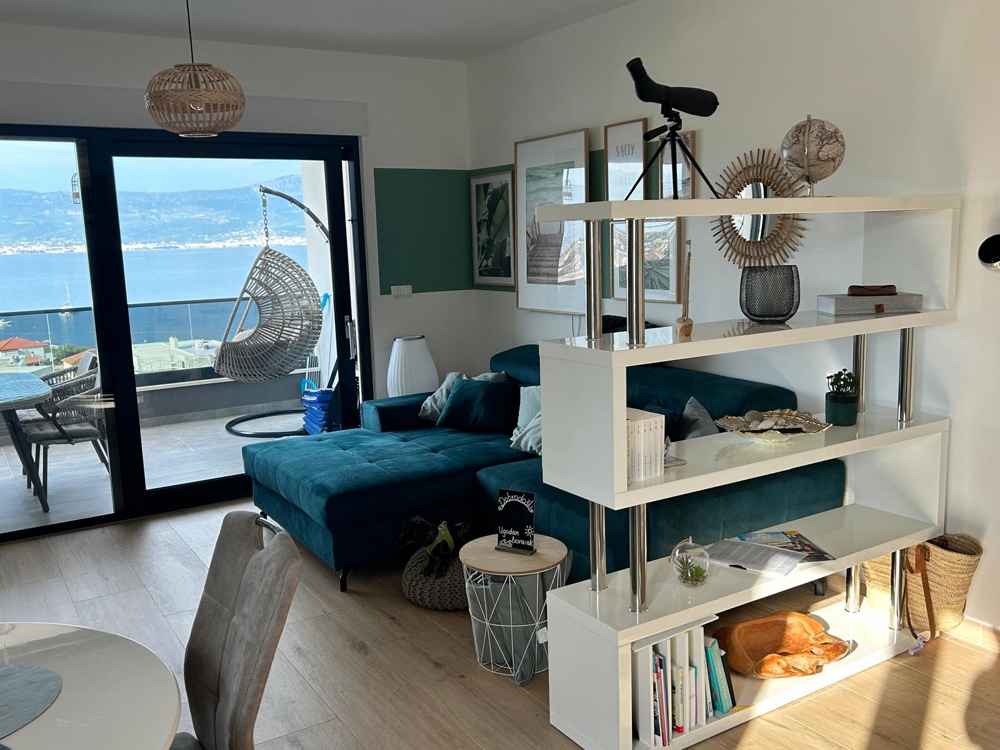 Obývací pokoj s výhledem na moře a závěsné křeslo