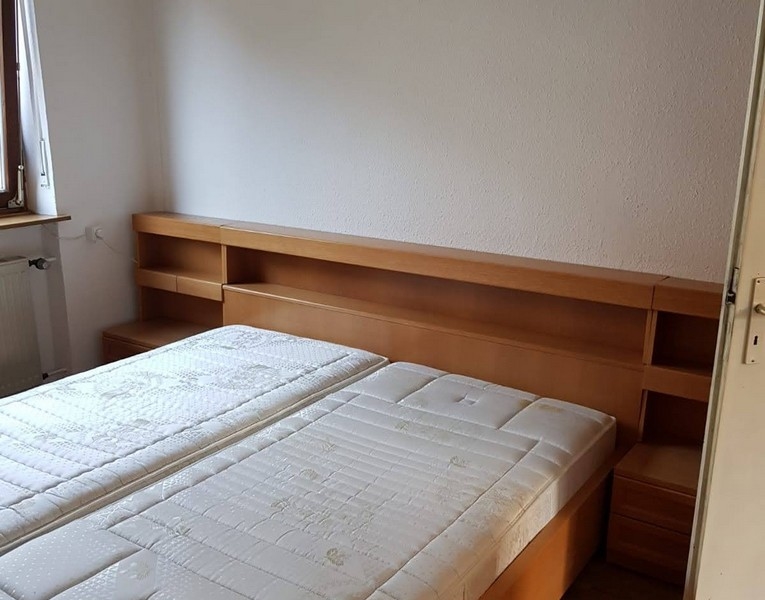 Manželská postel s dřevěným rámem a matracemi