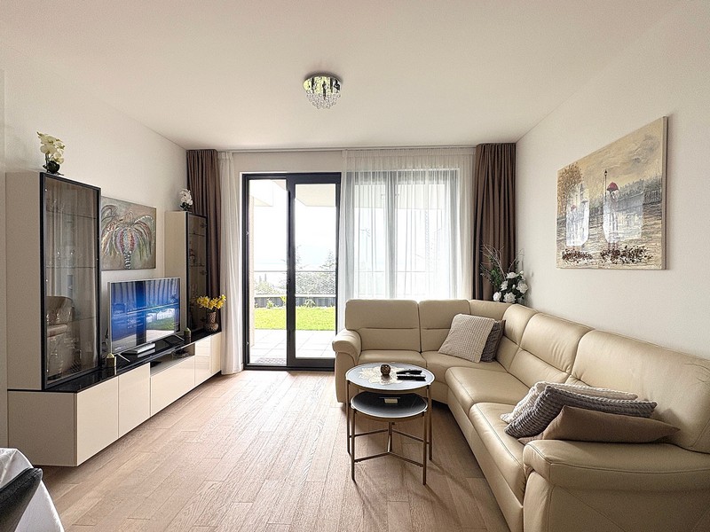 Zařízený obývací pokoj s výhledem do zahrady.