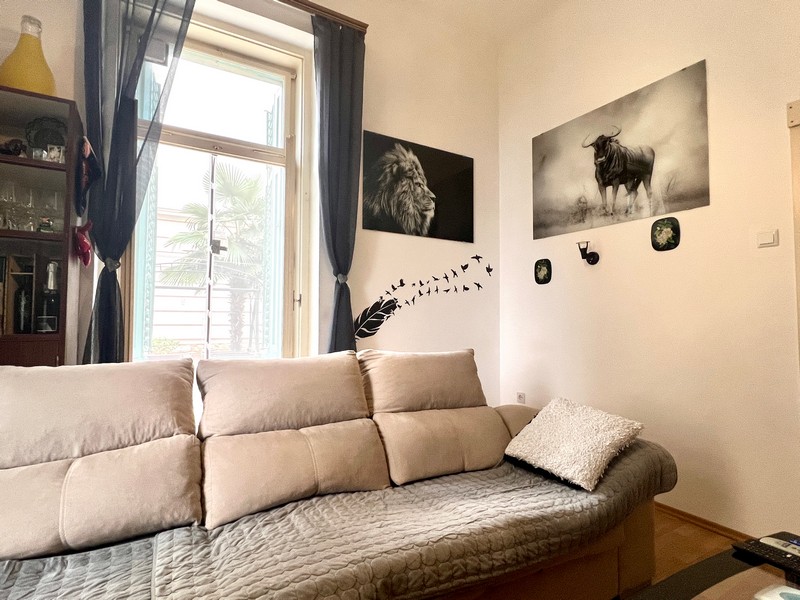 Obývací pokoj s pohovkou a nástěnnými malbami