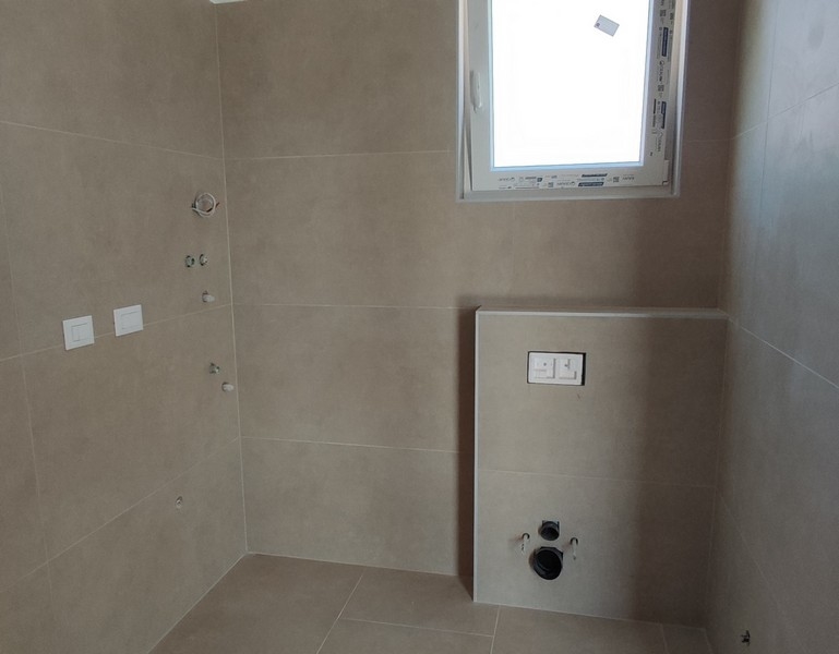 Moderní kachlová koupelna s oknem a přípojkami