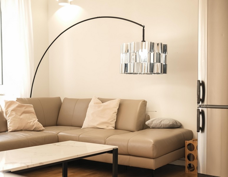 Světlý obývací pokoj s designovou lampou a koženou pohovkou