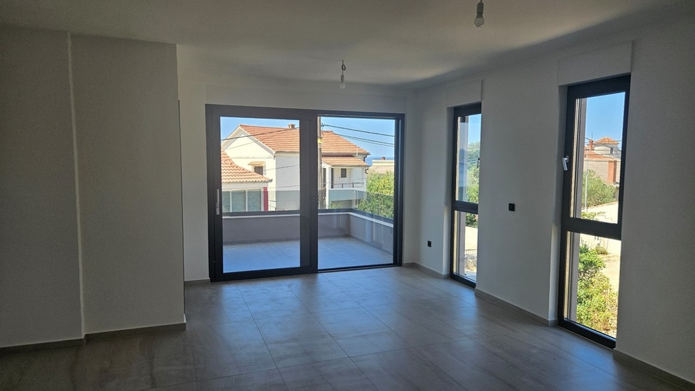 Světlý obývací pokoj se vstupem na balkon