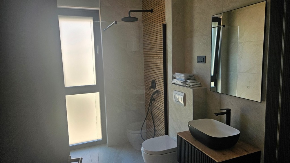 Koupelna se sprchovým koutem a zrcadlem