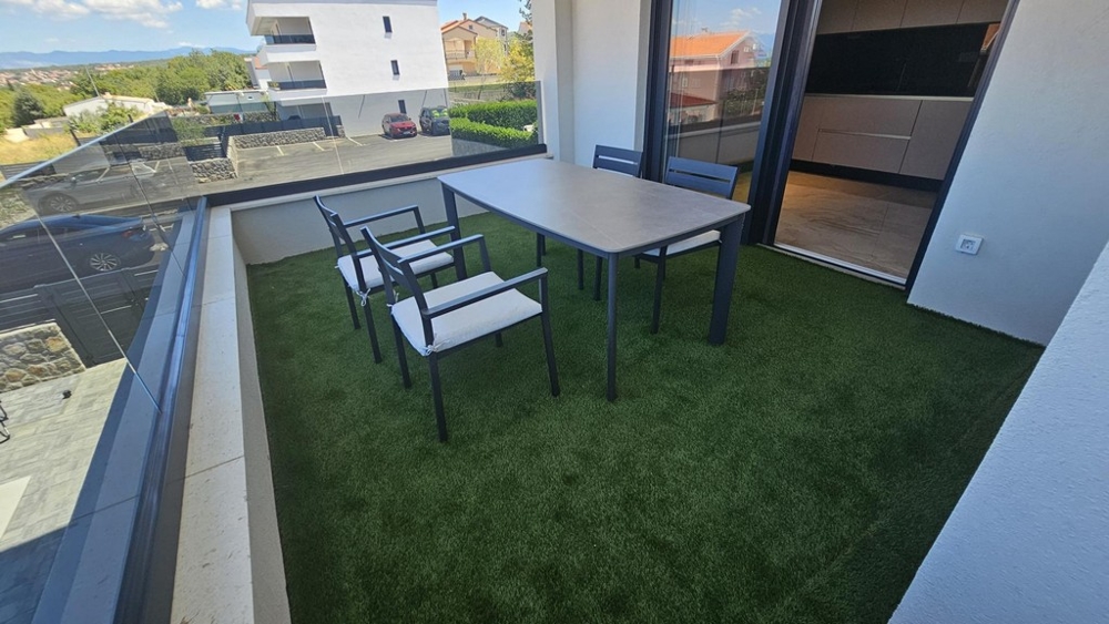 Terasa s umělým trávníkem na pozemku A3698 na Krku v Chorvatsku.