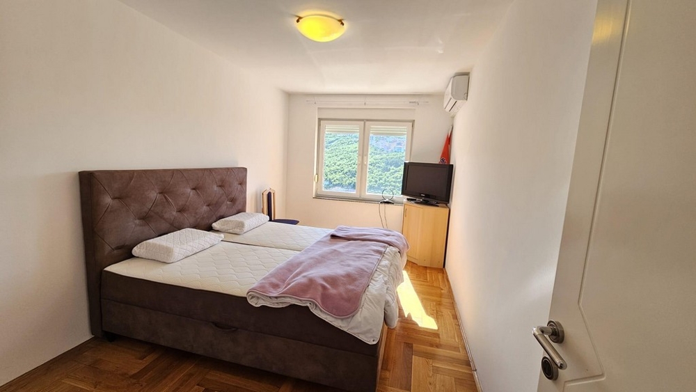 Ložnice s manželskou postelí a výhledem z okna