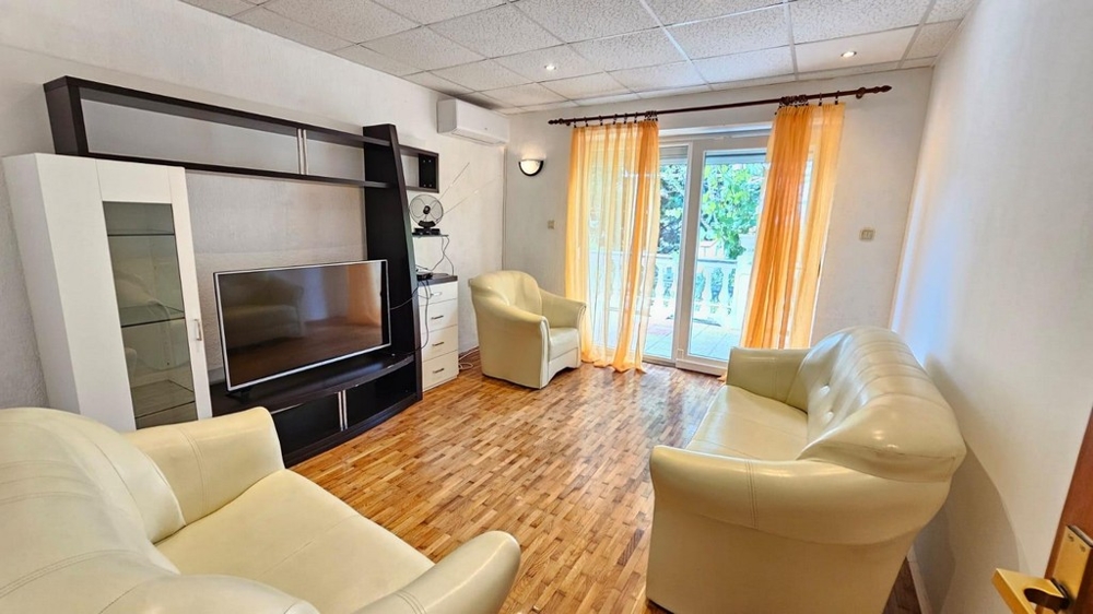 Světlý obývací pokoj s krémovým koženým nábytkem a vstupem na terasu