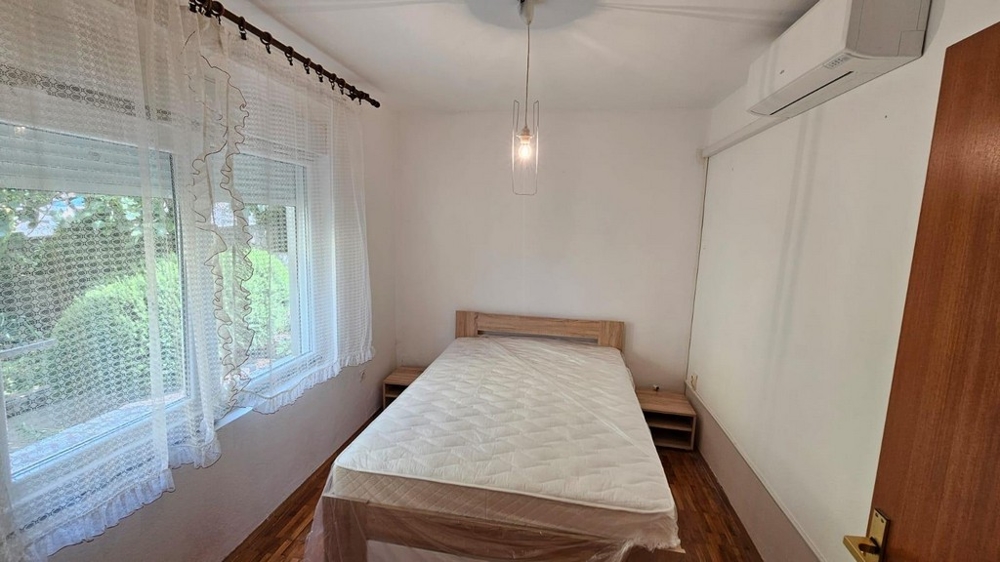 Druhá ložnice s velkým oknem a klimatizací