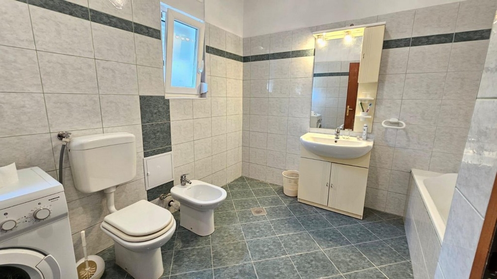 Koupelna s vanou, toaletou, bidetem a pračkou
