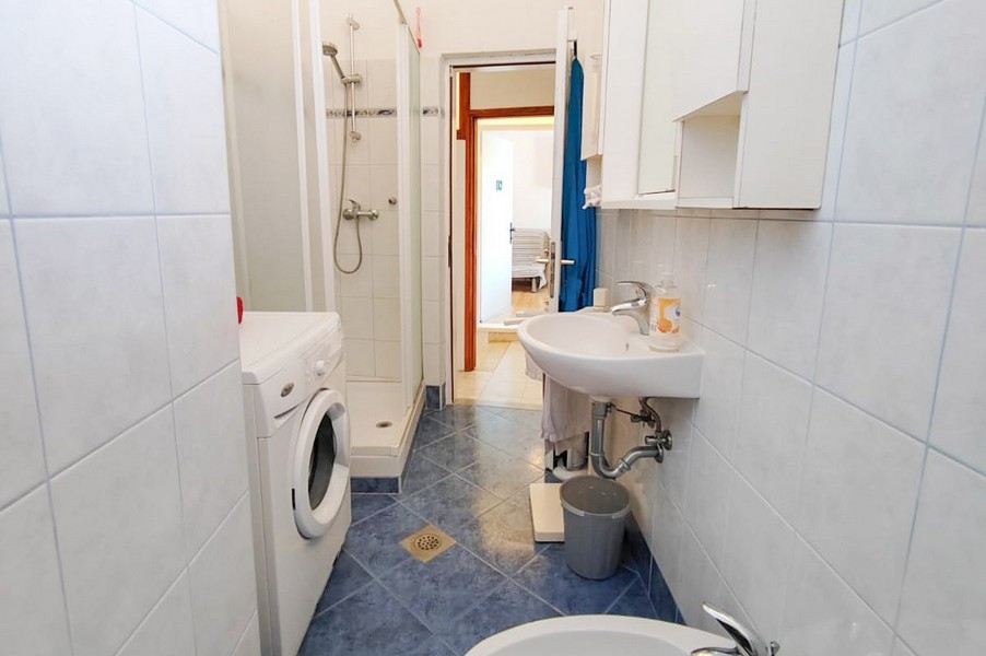 Koupelna se sprchovým koutem a pračkou