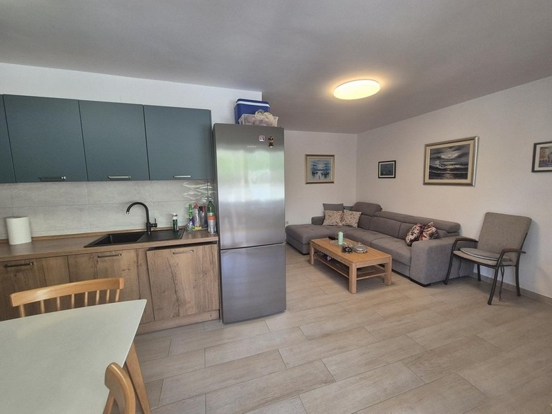 Otevřená kuchyně s obývací částí a rohovou pohovkou