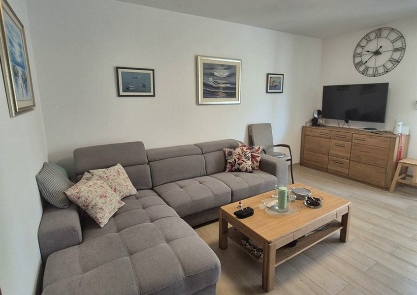 Obývací část s šedou rohovou pohovkou a konferenčním stolkem