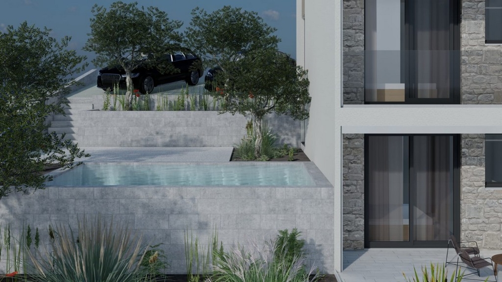 Bazén před budovou se zelení a parkovacími místy