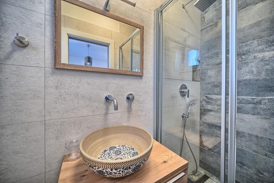 Koupelna s umyvadlem, zrcadlem a sprchovým koutem