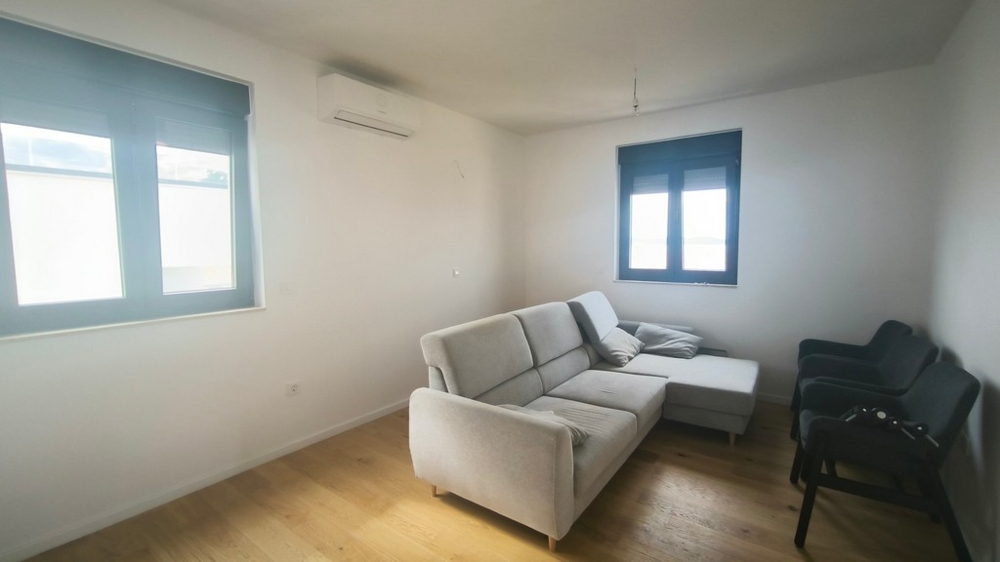 Světlý obývací pokoj s pohovkou a klimatizací