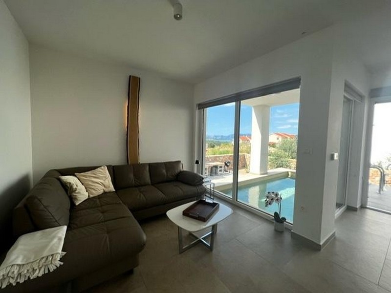 Obývací pokoj s pohovkou a výhledem na bazén v nemovitosti A3723, ostrov Krk