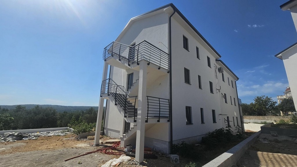 Zadní část nové budovy s venkovním schodištěm a okolím v Soline