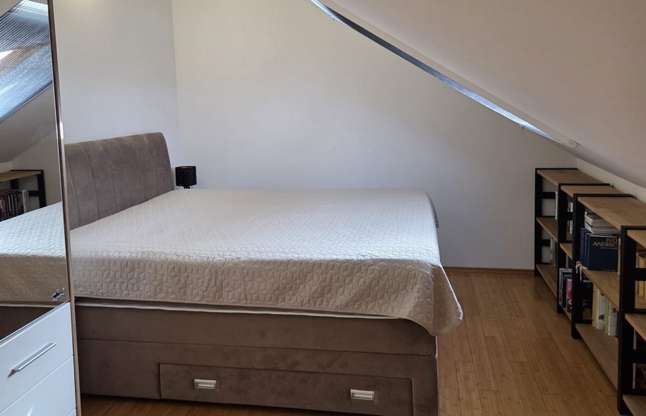 Ložnice s manželskou postelí pod šikmým stropem